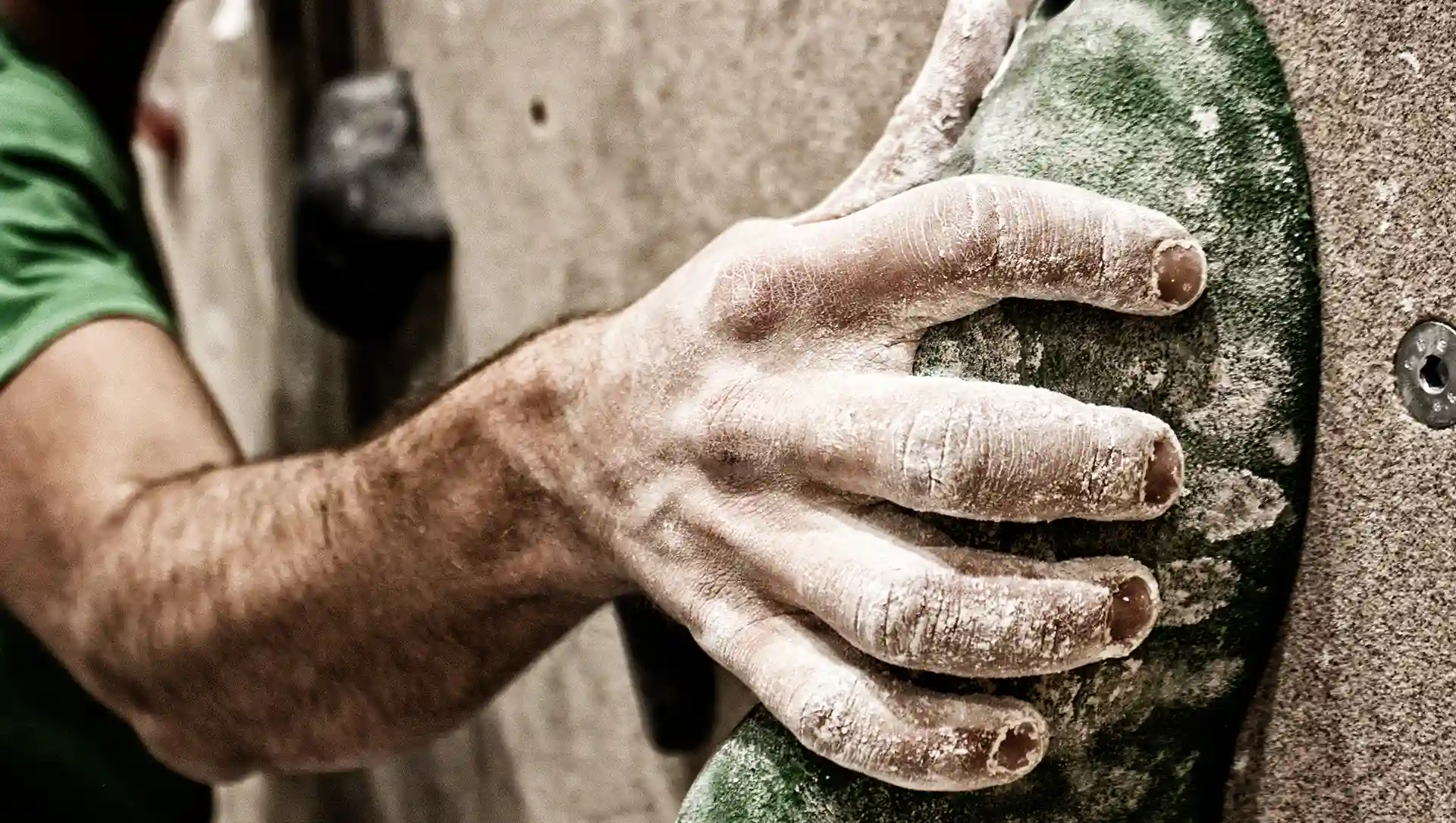Hintergrundbild. Die Hand eines Mannes hält sich an einem Vorsprung an der Wand